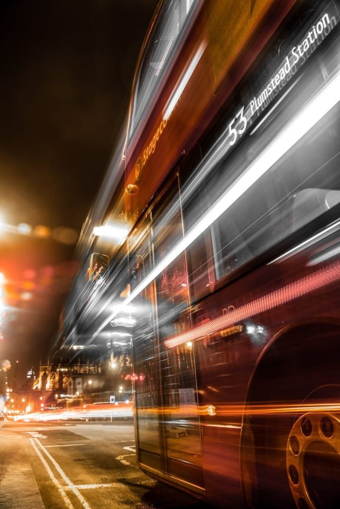 Dynamic long exposure capture of a London bus at night with vibrant light streaks.